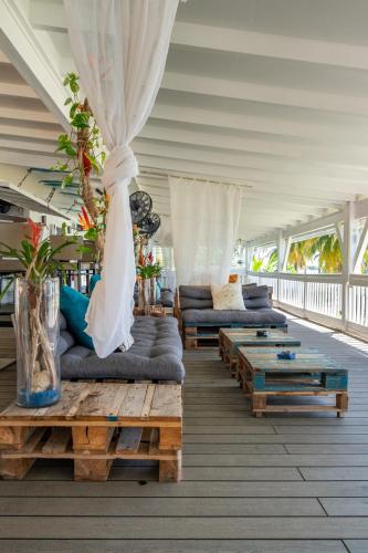 a living room with couches and tables on a porch at Zenitude Hôtel Résidences Le Salako in Le Gosier