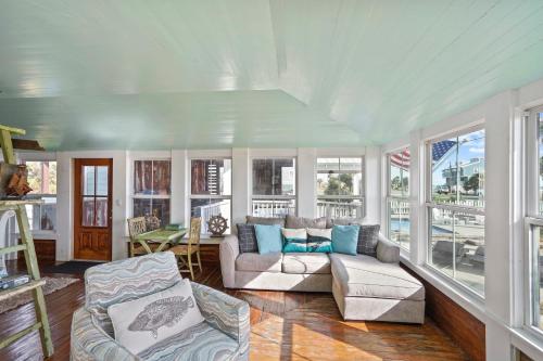 a living room with a couch and chairs and windows at Ivey House by Coastline Vacation Rentals in Saint Joe Beach