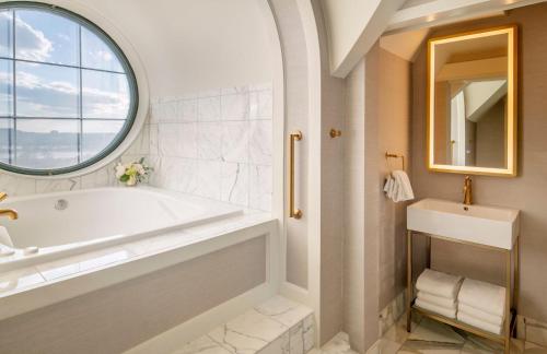 a bathroom with a tub and a sink and a window at Willard InterContinental Washington by IHG in Washington
