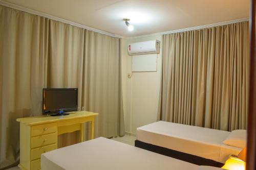 a hotel room with two beds and a television at Hotel Dan Inn Ribeirão Preto By Nacional Inn in Ribeirão Preto