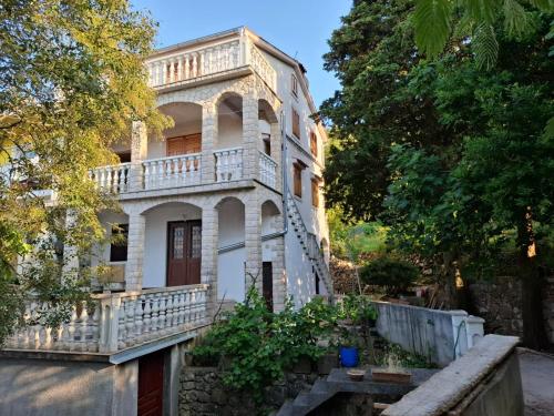 ein altes Haus mit einem Balkon an der Seite in der Unterkunft Apartment Boto - 20m from the sea in Smergo