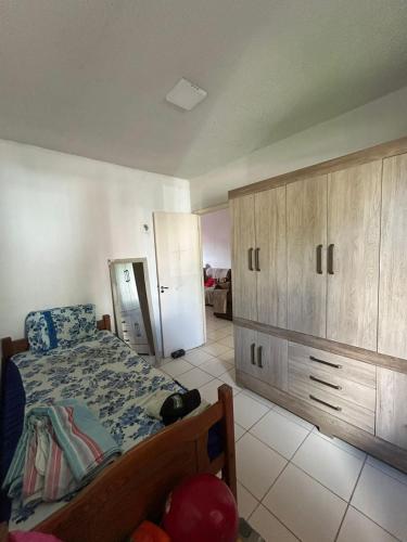 Un dormitorio con una cama y un gran armario de madera. en COP30 - Casa mobiliada - 3 quartos, en Ananindeua
