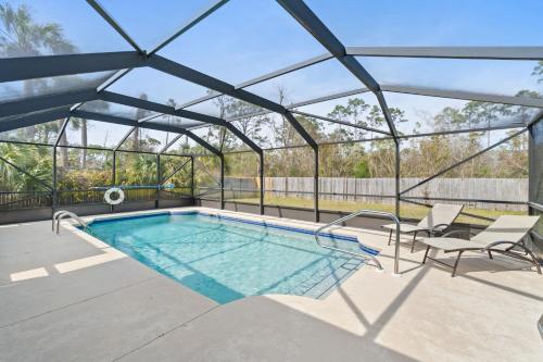 a swimming pool in a glass house with a swimming poolvisor at Mermaid Landing - St Joe Beach by Coastline Vacation Rentals in Saint Joe Beach