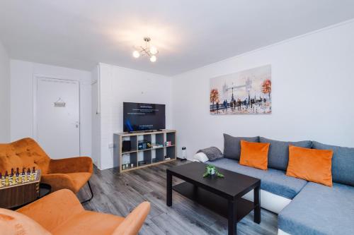a living room with a blue couch and orange chairs at Central Nottingham 3 bed house with Driveway in Nottingham