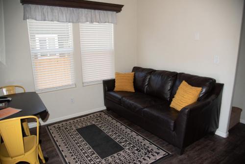 a black leather couch in a living room with a desk at La Sal Vista Cabin #08 in Moab