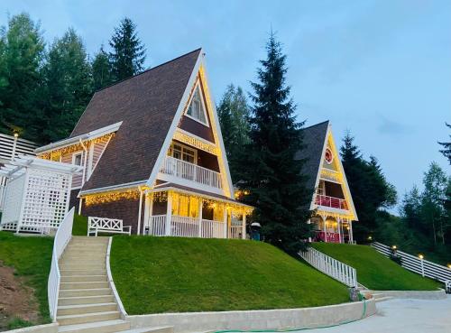 una grande casa con luci sulla parte anteriore di Цілий триповерховий будинок FREEMAN-3 над річкою з альтанкою та грилем a Bukovel