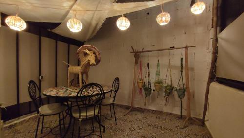 Maison en exclusivité 2 chambre Place Jemma El Fna في مراكش: غرفة طعام مع طاولة وكراسي وأضواء