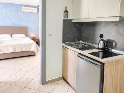Una cocina con fregadero y una cama en una habitación. en VILLA IATROU, en Potos