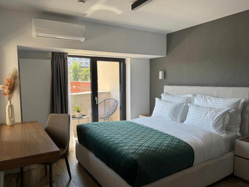 a bedroom with a bed and a table and a window at Novos Luxury Apartments in Bucharest