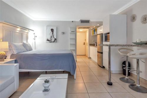 una camera da letto bianca con un letto e una cucina di Departamento de Lujo Frente al Mar - Miami Beach a Sunny Isles Beach