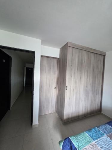 a bedroom with a wooden cabinet and a bed at Apartaestudio 302 Acogedor y Moderno Tulua in Tuluá