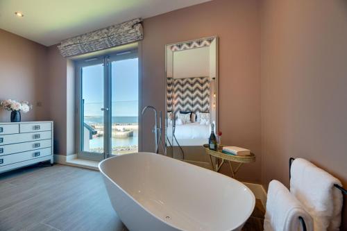 un ampio bagno con vasca e una camera da letto di Coot's Nest Seahouses a Seahouses