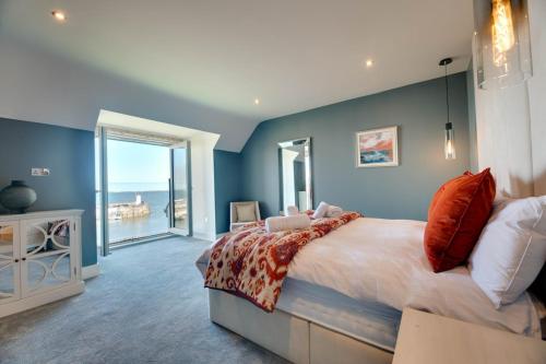 una camera da letto con un letto grande con vista sull'oceano di Coot's Nest Seahouses a Seahouses