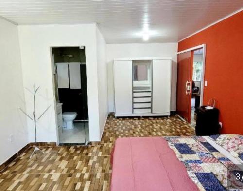 a room with a bed and a bathroom with a toilet at Refúgio Sereno in Nova Friburgo
