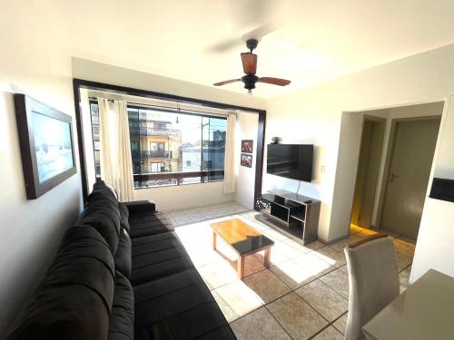 a living room with a couch and a tv at Apartamento Torres in Torres