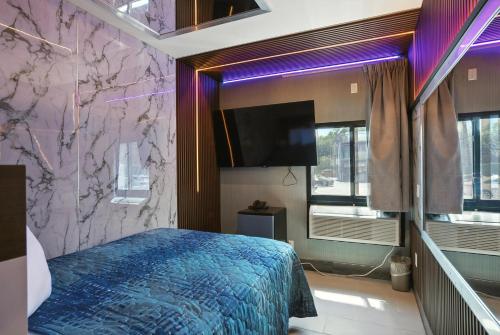 a bedroom with a bed and a wall with purple lights at Andrea Motel Inn & Suites in Bronx