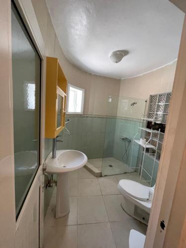 a bathroom with a sink and a toilet and a shower at Eskapaz luxury in Sosua
