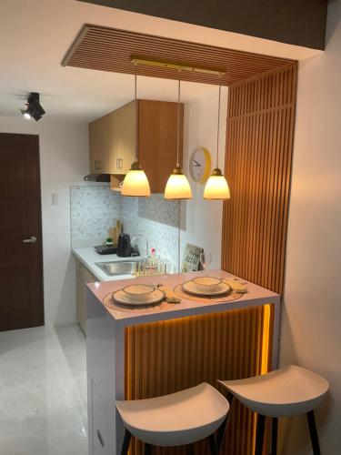 マンダウエ・シティにあるCondo Casa Mira Towers Mandaueの島付きのキッチン(椅子2脚、カウンタートップ付)