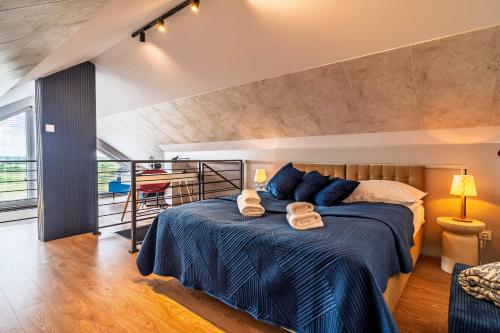 a bedroom with a bed with two towels on it at Morze Apartamentów Apartament West Łeba A19 in Łeba