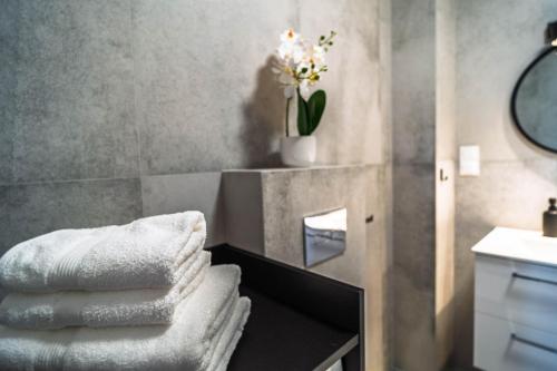 a bathroom with a pile of towels and a sink at Morze Apartamentów Apartament West Łeba A19 in Łeba