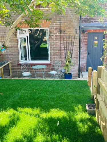 a yard with green grass and a window at Salisbury Getaway with Garden in Old Sarum