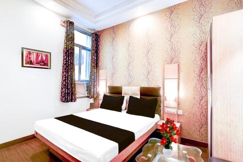 a hotel room with a bed and a window at Super Collection O Banipark Formerly Arena Villas in Jaipur