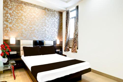 a bedroom with a large bed in a room at Super Collection O Banipark Formerly Arena Villas in Jaipur