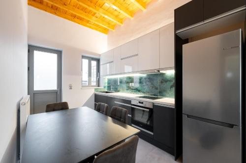 a kitchen with a table with chairs and a refrigerator at Porto & Mare Elegant Suites in Diakopto