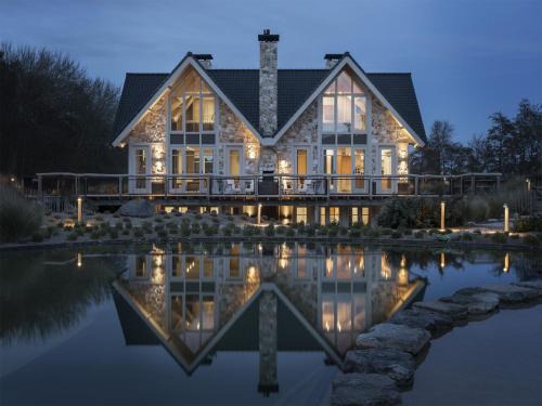 a house with a pond in front of it at Holiday Home with bubble bath in Noordwijk in Noordwijk