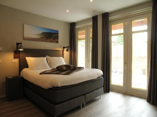 a dog laying on a bed in a bedroom at Holiday Home with bubble bath in Noordwijk in Noordwijk