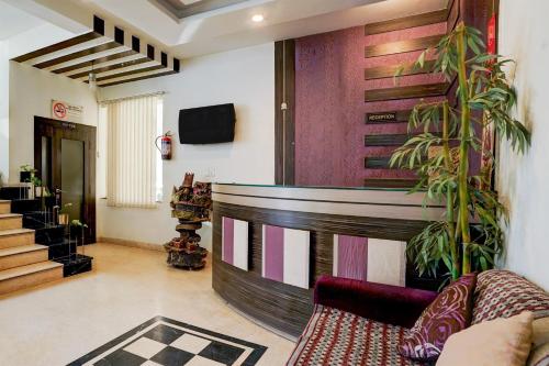 a living room with a couch and a wall at Super Collection O Banipark Formerly Arena Villas in Jaipur