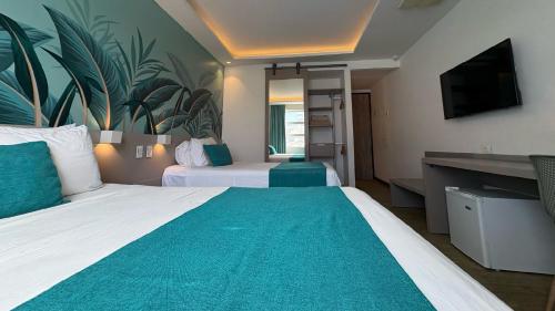 a hotel room with two beds and a flat screen tv at Hotel Portobelo Plaza las Ámericas in San Andrés