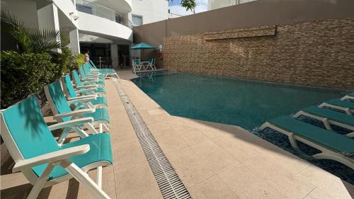 a row of chairs sitting next to a swimming pool at Hotel Portobelo Plaza las Ámericas in San Andrés