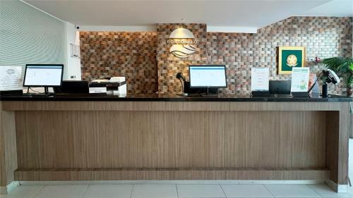 a restaurant with a counter with computers on it at Hotel Portobelo Plaza las Ámericas in San Andrés