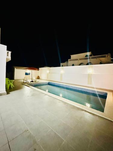 a swimming pool on top of a building at night at Villa Soltana in Zarzis