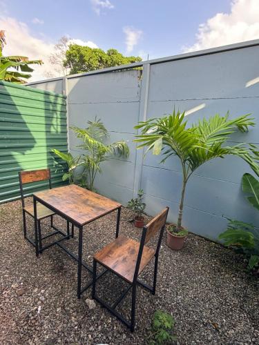 カウイータにあるPuerta del Sol Apartmentの植物の植えられた庭の椅子2脚とテーブル