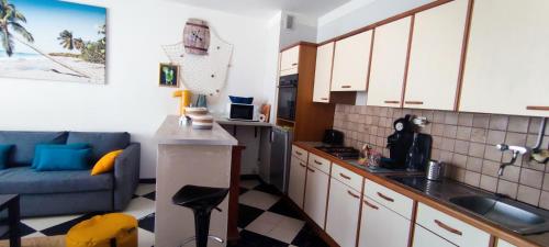 a kitchen with a couch and a table in a room at Appart détente à 200m de la Plage in Le Grau-du-Roi