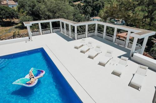 a woman is riding a paddle board in a swimming pool at Casa Blanca in Dosríus