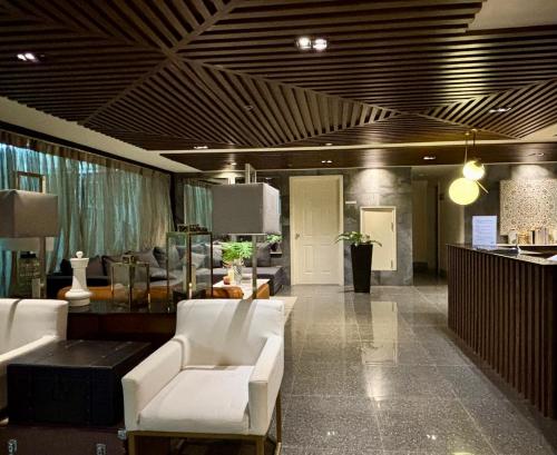 a lobby with white chairs and tables in a store at Minimalist studio unit in Davao City