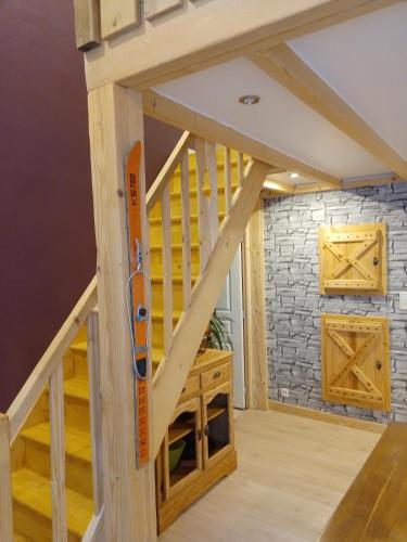 a room with a wooden staircase with a vaulted ceiling at Refuge chaleureux pour des vacances en famille in Le Lioran