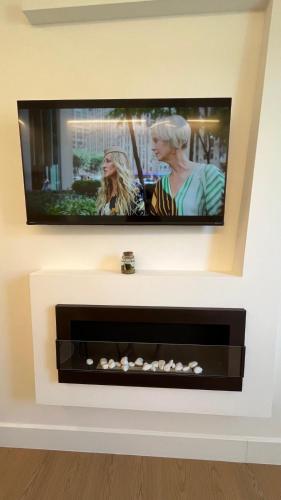 a flat screen tv on a wall with a fireplace at Dionisio 7 in Pescara