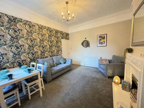 a living room with a couch and a table at Seabreeze Apartment 1, Whitley Bay in Cullercoats