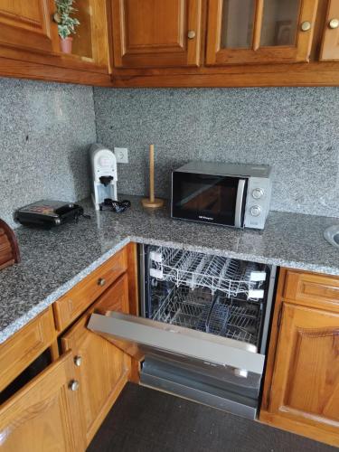 a kitchen with a toaster oven and a microwave at Casinha da Eira in Monção