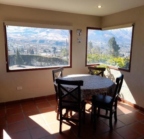 a dining room with a table and chairs with a view at Casa Viva - Tafi del Valle in Tafí del Valle