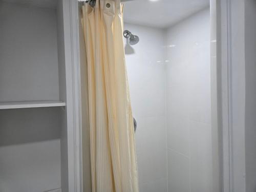 y baño con ducha con cortina amarilla. en One Bed basement Room, en Brampton