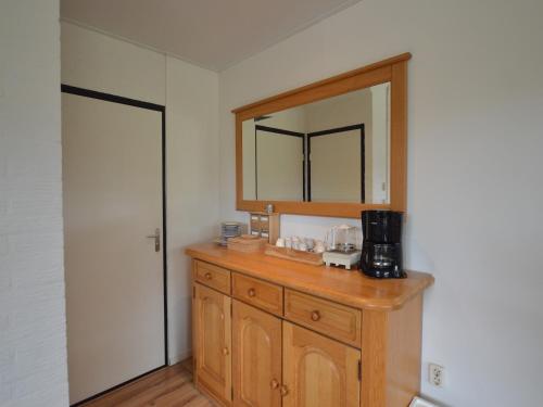 a bathroom with a wooden dresser with a mirror at Holiday Home in Stramproy Nature Reserve in Stramproy