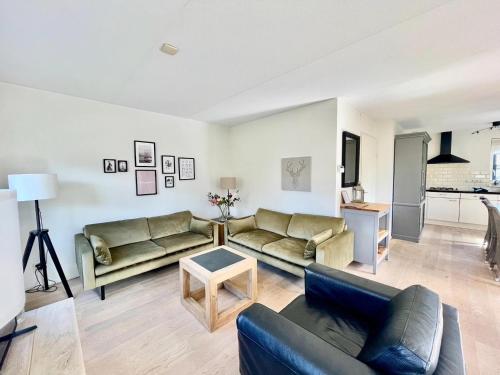 a living room with two couches and a table at Holiday Home in Schoorl near Sandy Beaches in Schoorl