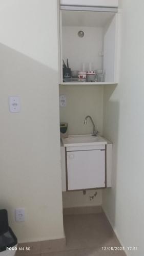a small white kitchen with a sink in a room at Pousada santos 1, kitnet confortável com ar condicionado in Londrina