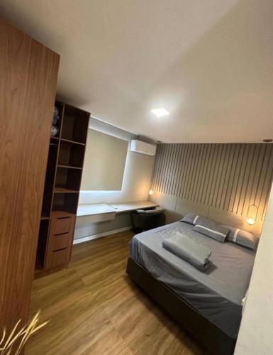 a bedroom with a bed and a book shelf at High Standard coral beach in Santa Cruz Cabrália