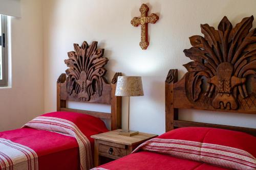 a bedroom with two beds and a cross on the wall at Los Amores 09 in Bucerías